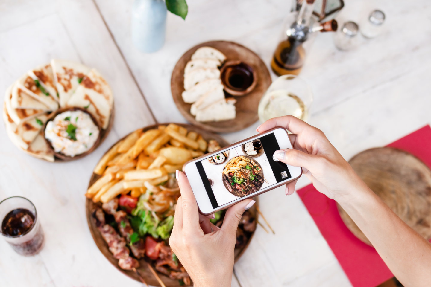 Woman taking photo of mix grill dish